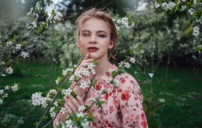 Young beautiful woman in the cherry-blossoming garden. Young beautiful woman in the cherry-blossoming garden.